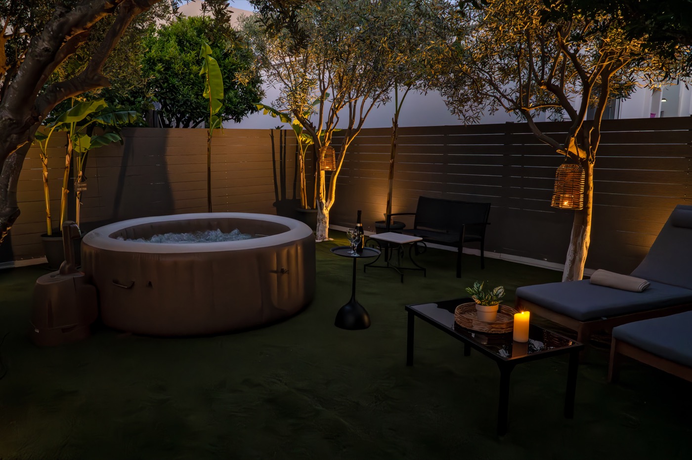 The garden at Home Away From Home after sunset, lanterns lit around the hot tub